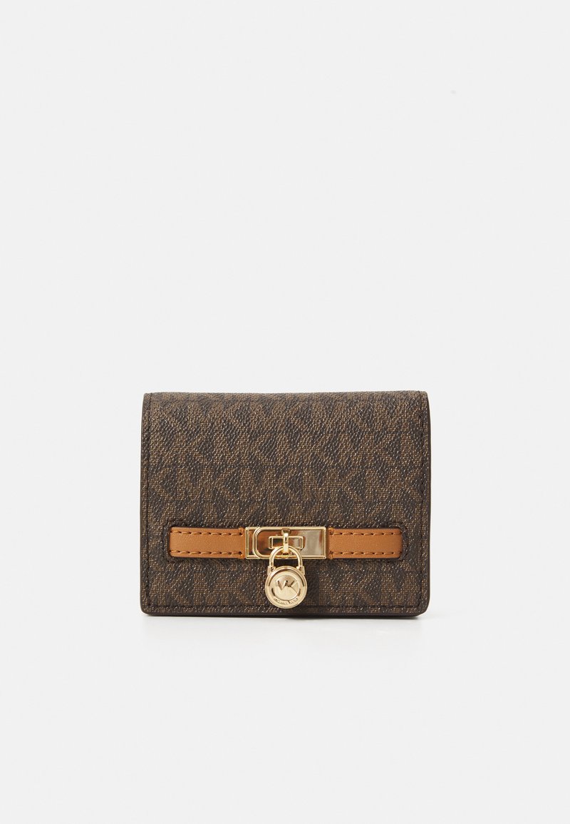 Portafoglio monogramma marrone compatto con dettaglio in oro a forma di lucchetto e accentuazione in pelle beige, su sfondo bianco.
