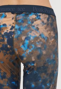 Sötétkék derékpánttal rendelkező harisnyanadrág, melynek színes, batikolt mintája barna, kék és bézs árnyalatokban pompázik. Simaságával és testhezálló kialakításával emelkedik ki.