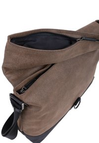 Borsa a tracolla in tessuto marrone con spallaccio regolabile nero, cerniera superiore aperta che rivela l'interno foderato in nero, e dettaglio anello metallico alla base.