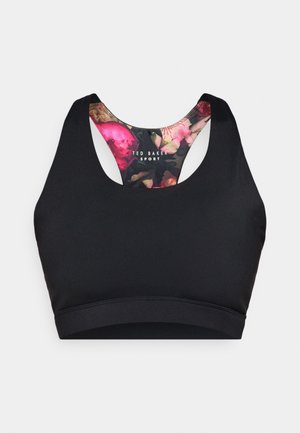 Sort sports-bh med en blomster mønstret foring. Har et racerback-design og en glat tekstur. Mærket "Ted Baker Sport" er synligt.
