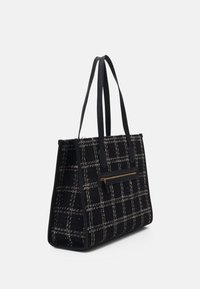 Sac fourre-tout en tweed noir à motif quadrillé, doté d'une poche zippée avant et de poignées en cuir. Forme structurée avec une finition texturée.
