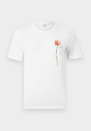 Άσπρο κοντομάνικο μπλουζάκι με ένα ροζ τριαντάφυλλο και ένα λευκό φιόγκο δεμένο γύρω από το μίσχο του στην αριστερή πλευρά του στήθους.