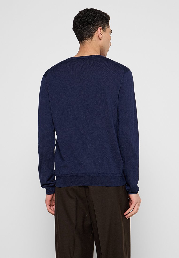 Maglione blu navale con un design a maglia texturizzata, scollo a girocollo e polsini e orlo a coste. Presenta dettagli contrastanti sulle spalle e una vestibilità morbida.