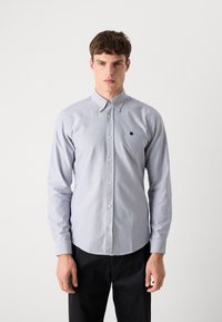 Lichtblauw overhemddshirt van katoen met lange mouwen. Bevat een kraag, een voorplacket en een klein logo op de linkerkant van de borst.