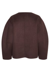 Rudas vilnonis švarkas su kvadratine forma, apvali apatine dalimi ir nuleistomis pečių linijomis. Yra švarus nugaros dizainas su minimaliomis siūlėmis ir be matomų užsegimų.