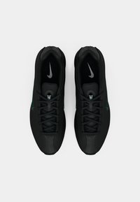 Par de sapatilhas Nike pretas com atacadores, vistas de cima, mostrando as palmilhas interiores com o logótipo Swoosh branco da Nike.