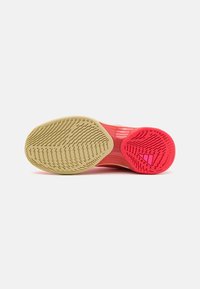 Sportssko såle med en gummioverdel i lys rosa og beige, teksturert med forskjellige gripe-mønstre for godt feste.