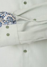 Groen geruit overhemd met een patroon aan de manchetten, versierd met blauwe en beige bloemdetails. Het heeft bijpassende knopen en een gestructureerde stof.