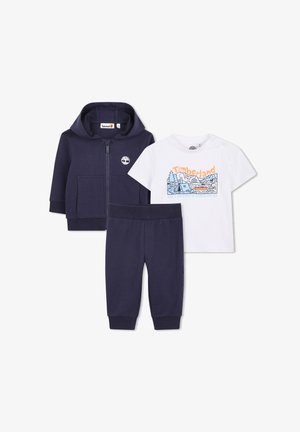 Granatowy komplet bluzy na suwak i spodni oraz biała koszulka z krótkim rękawem z kolorową grafiką pikniku na łonie przyrody i logo Timberland.