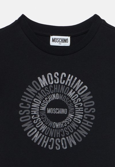 Μαύρο παιδικό t-shirt Moschino με λαμπερό ασημένιο κείμενο "MOSCHINO" επαναλαμβανόμενο σε συγκεντρικούς κύκλους στο μπροστινό μέρος.