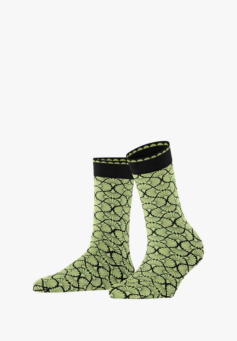 Zielone skarpetki w wzór liści na czarnym tle, z żeberkowym czarnym mankietem i gładką teksturą.