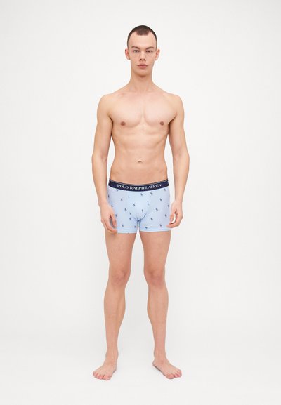 Boxeri de culoare albastră deschisă cu un tiv bleumarin, prezentând un model repetitiv de logo-uri mici de polo. Materialul are o textură Netedă.