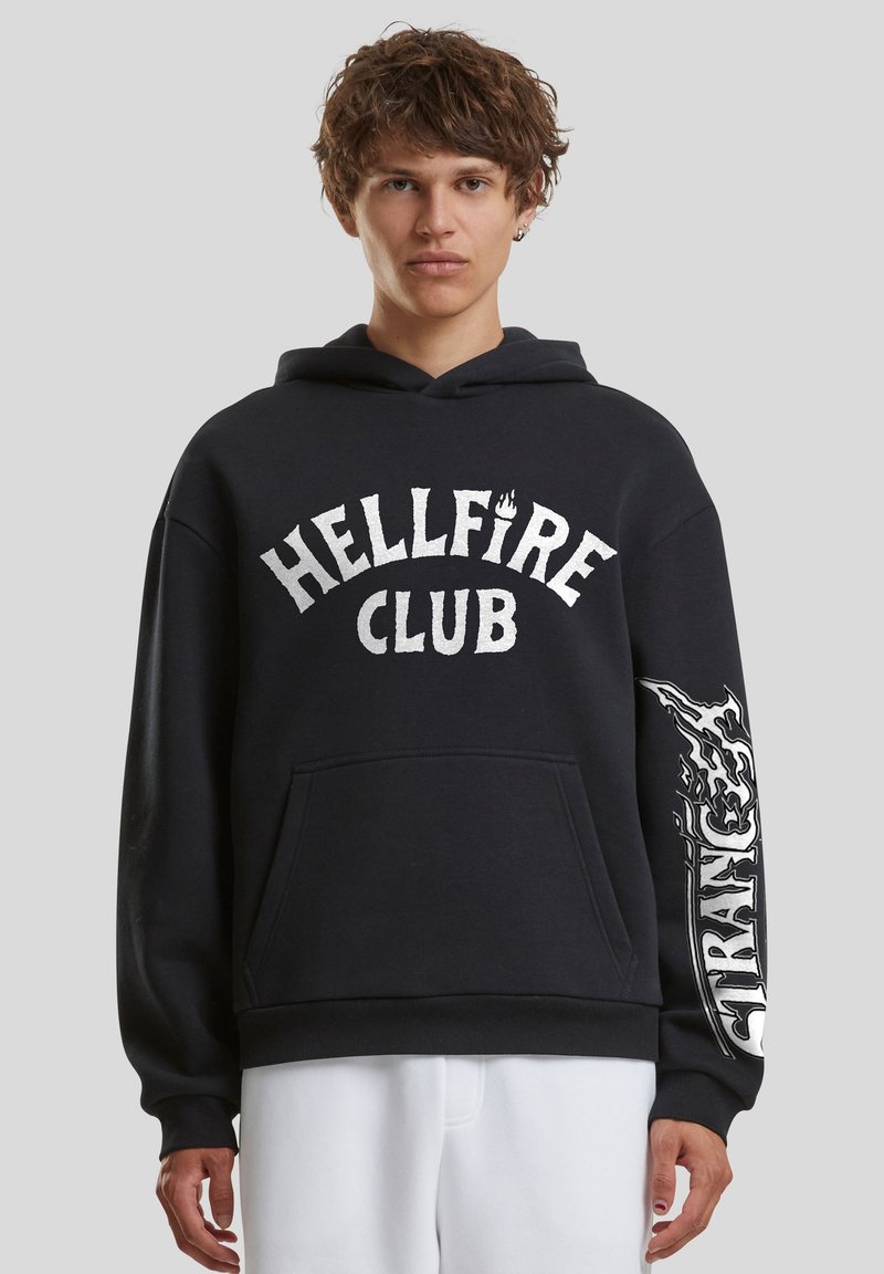 Sweat à capuche en coton noir avec une poche kangourou à l'avant, l'inscription « HELLFIRE CLUB » et un motif de flamme sur la manche droite.