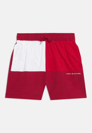 Herren-Badeshorts mit roten, weißen und burgunderfarbigen Farbfeldern, elastischem Bund, Kordelzug und kleinem Tommy Hilfiger Logo am rechten Bein.