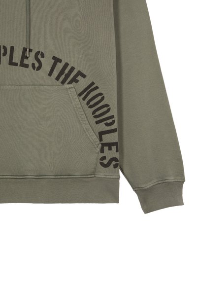 Sweatshirt à capuche vert olive en coton, avec une poche avant et un grand texte noir indiquant "THE KOOPLES" sur le côté.