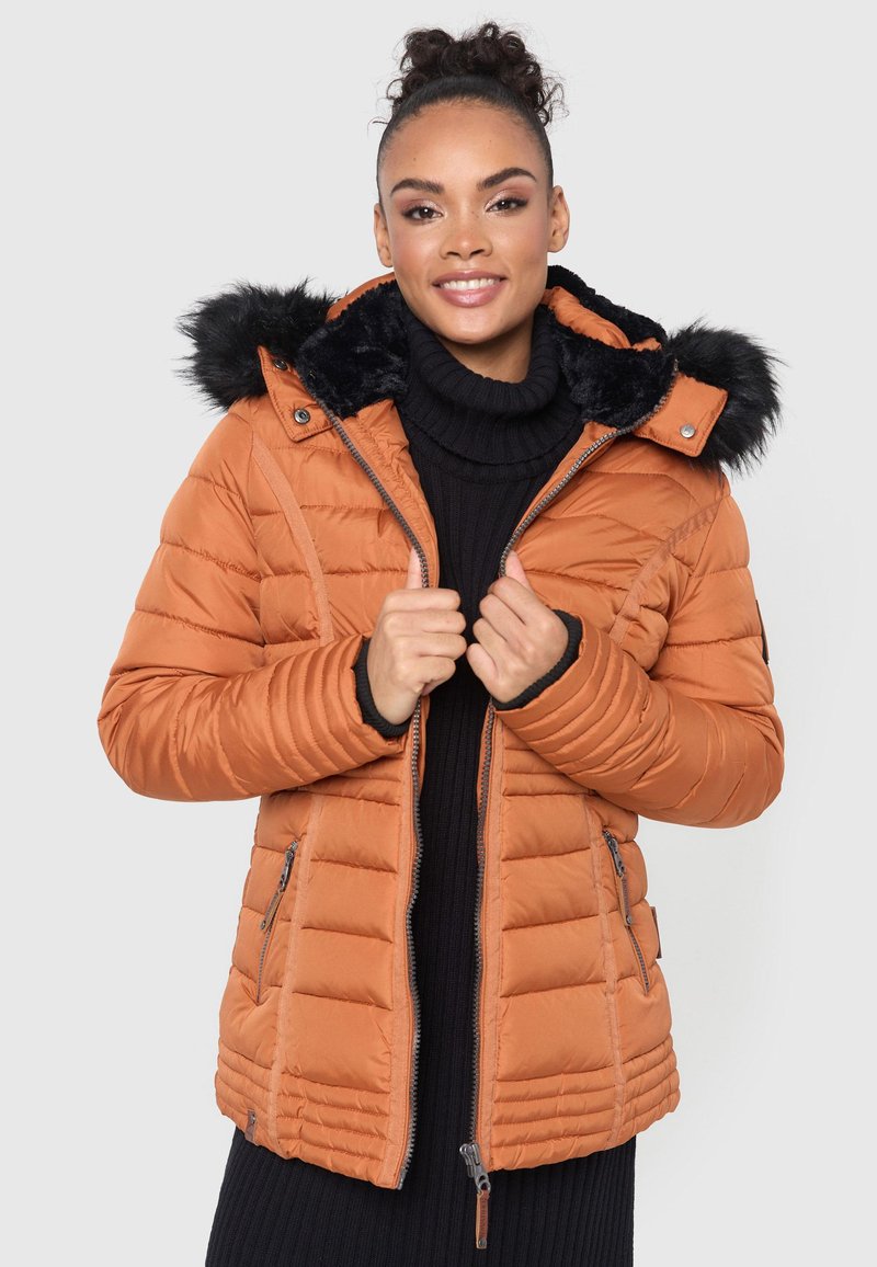 Orange padded jacket with a removable black fur-lined hood, zippered pockets, and ribbed cuffs, worn over a black turtleneck sweater.