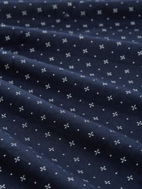 Navyblauer Stoff mit glatter Textur, der ein weißes Blumendessin aus kleinen Kreuzen und Punkten aufweist, die gleichmäßig über die Oberfläche verteilt sind.