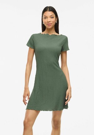 Robe verte à manches courtes avec un motif texturé, décolleté à volants et silhouette ajustée, s'étendant jusqu'à mi-cuisse.