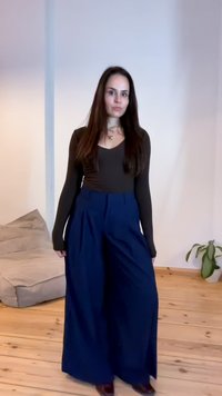 Bredde ben navy bukser med plisseringer, parret med en tætsiddende brun langærmet top. Glat stof, minimal detaljering og afslappet pasform.