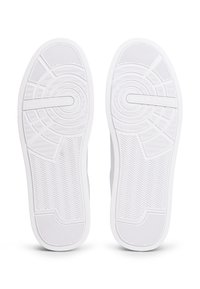 Bijeli potplati tenisica s teksturiranim uzorcima, središnjim kružnim dizajnom i uzorkom u cik-cak za bolje prianjanje. Logo je prisutan blizu područja prstiju.