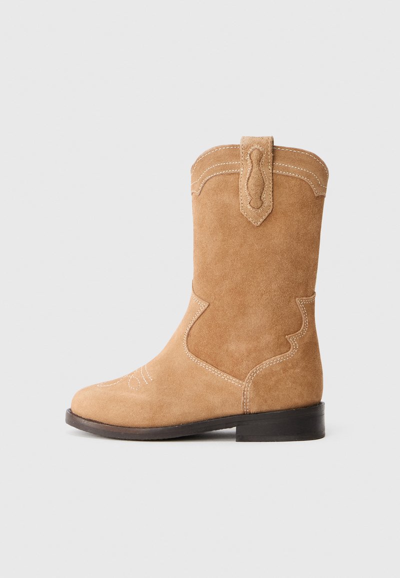 Stivale da cowboy in suede color testa di moro con un design cucito, una parte superiore curvata e un piccolo supporto sul retro. Presenta un tacco basso e una suola liscia.