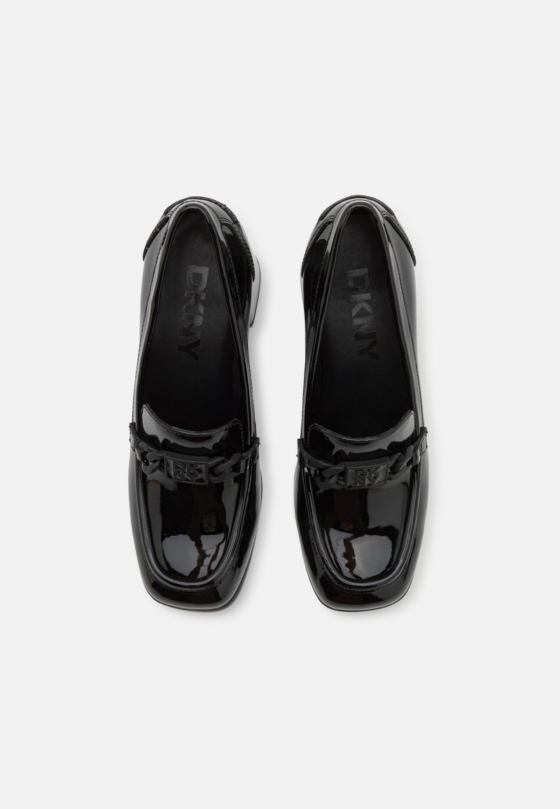 Mocassins en cuir verni noir avec un bout carré, des détails en chaîne et un logo DKNY subtil sur la semelle intérieure. Fini lisse et brillant.