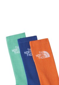 Tres pares de calcetines hasta la rodilla en verde menta, azul y naranja, con textura acanalada y el logo de "The North Face" en blanco.