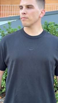 Fekete pamut póló rövid ujjakkal, a mellrészen egy kis, dombornyomott Nike logóval. Egyszerű, kerek nyakú dizájn.