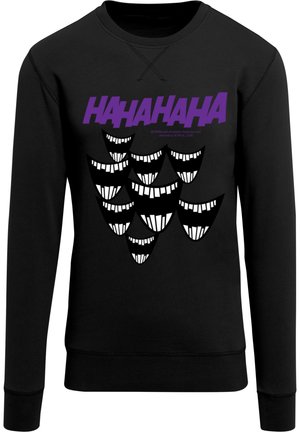 Musterniga mustriga mustus, millel on graafiline kujundus, millel on tekst "HAHAHA" lilas värvitoonis ja hulk stiliseeritud valgeid hambaid ning näo outlines.