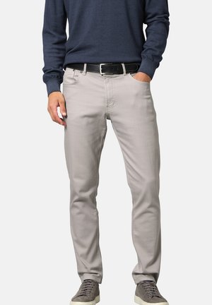 Helle graue Hose aus weichem Stoff, tailored fit, mit fünf Taschen, Knopfverschluss und einem schwarzen Gürtel. Kombiniert mit grauen Sneakern.