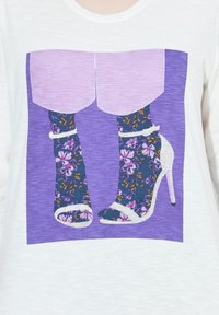 Graafinen esittää korkokenkää ja kukkakuosisia sukkia. Värit sisältävät purppuraa, laivastonsinistä ja valkoista. Suunnittelu on rohkea, jossa on vahvat kontrastitekstuuri.