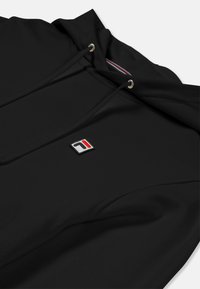 Felpa nera realizzata in morbido tessuto, con cappuccio regolabile, logo ricamato in rosso e blu, e superficie liscia e testurizzata.