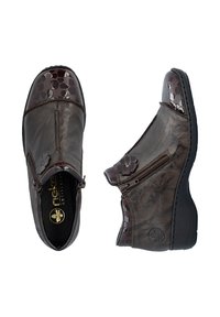 Bottines en cuir marron foncé avec fermetures éclair latérales, bouts brillants texturés et petites décorations florales sur fond blanc.