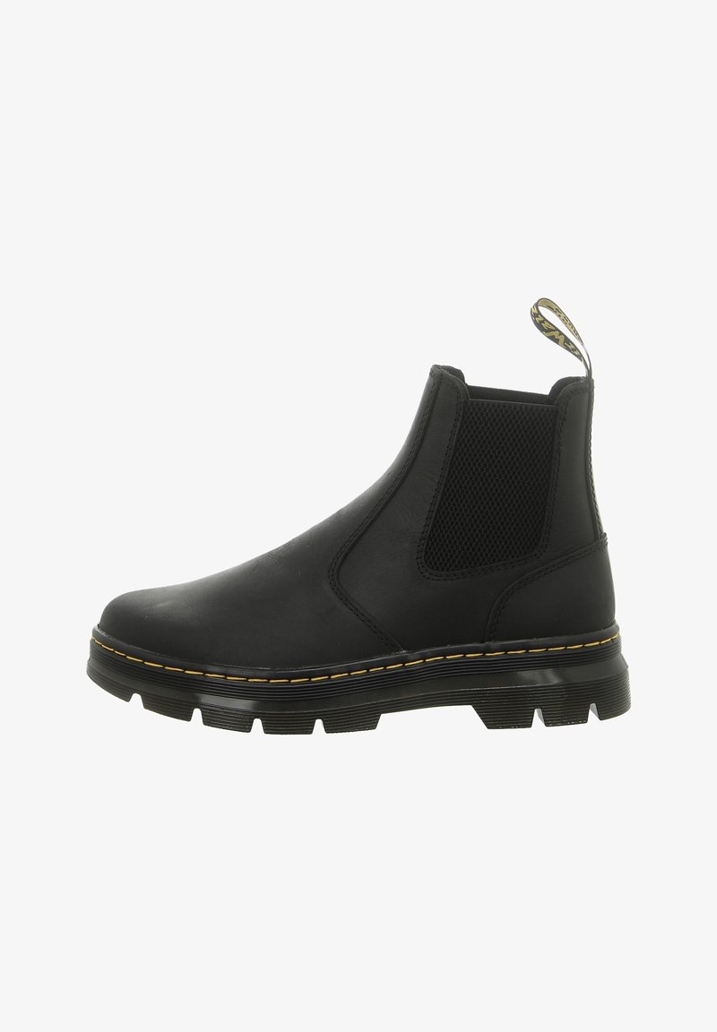 Bottine noire en cuir avec panneau latéral élastique, semelle épaisse à crampons, surpiqûres jaunes et languette de tirage marquée à l'arrière.