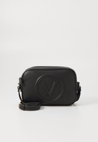 Svart läder crossbody-väska, texturerad yta, rektangulär form, med en cirkulär präglad logotyp och en avtagbar rem.