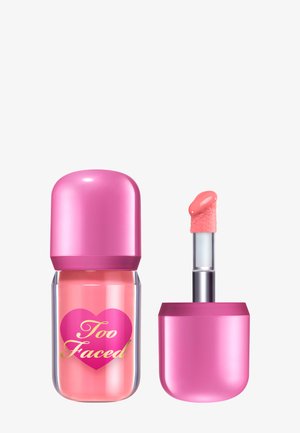 Too Faced Lippenprodukt in einem durchsichtigen Behälter mit einem pinkfarbenen Herzlogo. Verfügt über eine pinke, abgerundete Kappe und einen weichen, schrägen Applikator.