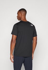 Μαύρο κοντομάνικο t-shirt από μαλακό ύφασμα, με στρογγυλή λαιμόκοψη και μικρή λεπτομέρεια λογότυπου στο επάνω μέρος της πλάτης.