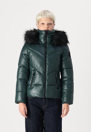 Veste rembourrée verte avec un col montant et une capuche en fausse fourrure noire. Présente des coutures en chevrons diagonales et deux poches latérales zippées.