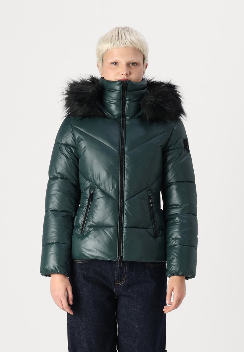 Green padded jacket with a high neck and black faux fur hood. Features diagonal chevron stitching and two zippered side pockets.