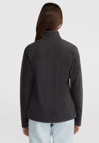 Donkergrijze fleecjacket met een hoge kraag en lange mouwen, zachte textuur en een afgeronde onderkant. Minimale details aan de achterkant.