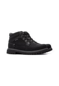 Botas negras de tobillo hechas de material sintético con un acabado texturizado, ojales de metal y una suela de tracción rugosa y con patrón.