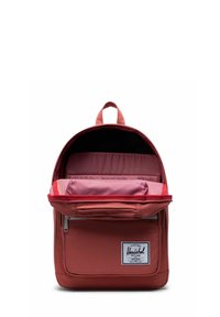 Sac à dos en tissu rouge avec une grande poche avant, un intérieur rayé et un compartiment principal zippé. Dispose d'une poignée supérieure pour le transport.