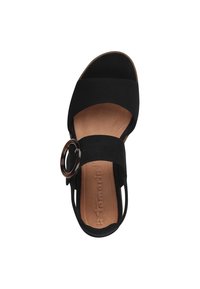 Sandalo aperto nero con design a fascia larga, un accento circolare, materiale morbido simile al camoscio e una soletta imbottita beige.
