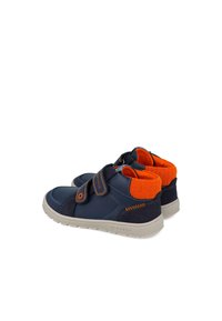 Zapatos azul marino con un cuello de forro polar naranja, que cuentan con una correa de Velcro, acentos de material sólido y ante, y una suela de goma gris claro.