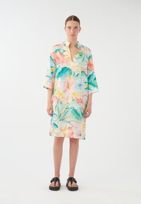 Robe à imprimé floral avec un col, présentant des couleurs vives comme le rose, le bleu et le vert. Coupe ample et manches trois-quarts. Texture de tissu douce.