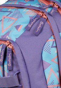 Sac à dos violet et bleu avec des motifs géométriques, en matériau synthétique, avec des fermetures éclair doubles et des tirettes de zip avec logo.