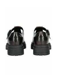 Chaussures en cuir noir avec une semelle épaisse, présentant un bout rond et un design découpé au niveau du talon. Détail de boucle remarquable sur le côté.