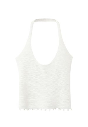 Crop top blanc en maille à col halter avec motif de points texturés et petite bordure à pompons en bas.