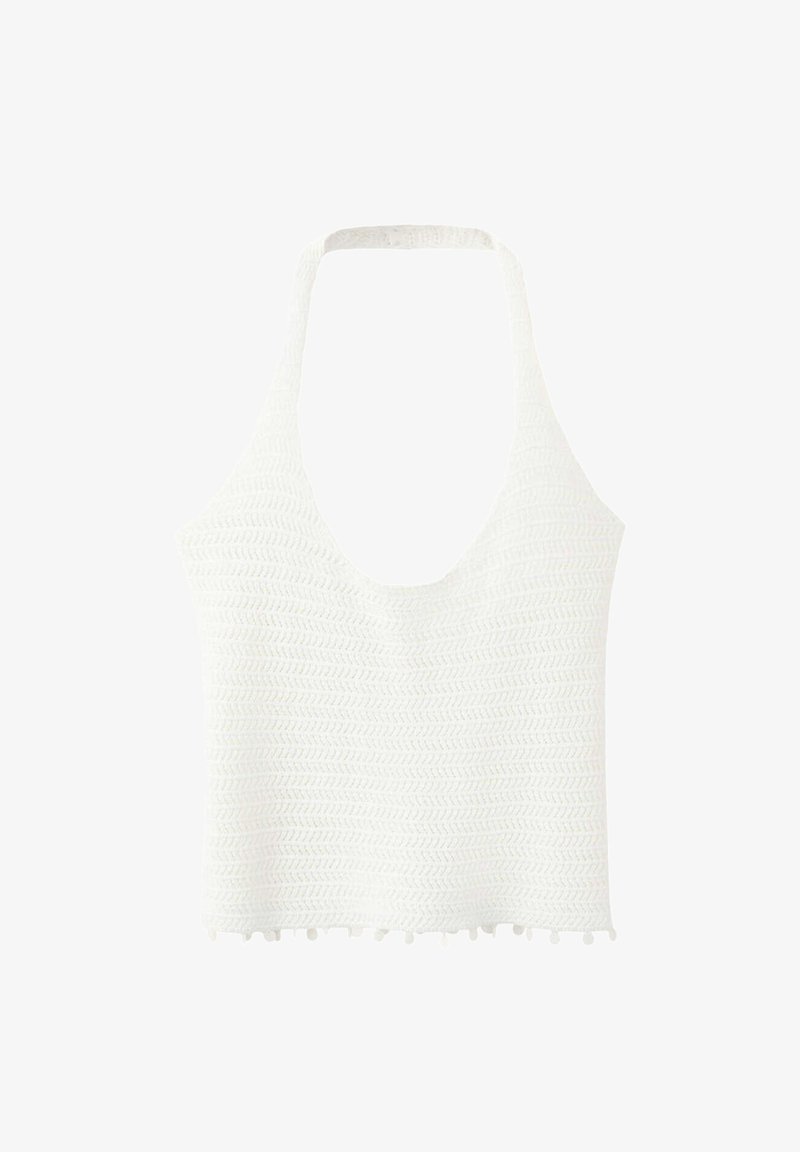 Crop top blanc en maille à col halter avec motif de points texturés et petite bordure à pompons en bas.