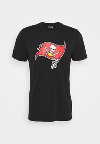 T-shirt en coton noir avec un graphique de drapeau des Buccaneers rouge, représentant un crâne et des os croisés, accentué de détails blancs et jaunes.